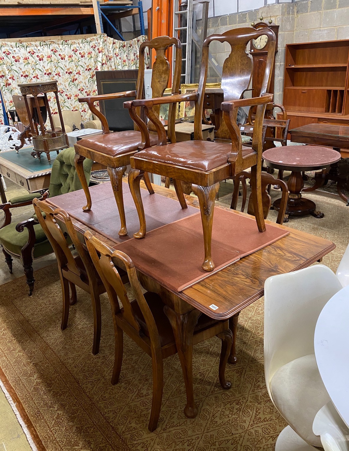 A Queen Anne revival figured walnut extending dining table, length 183cm extended, one spare leaf, width 83cm, height 75cm and six chairs, two with arms
